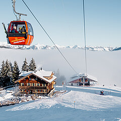 Rote Gondelbahn mit dem Restaurant und Skipiste im Hintergrund