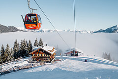 Rote Gondelbahn mit dem Restaurant und Skipiste im Hintergrund