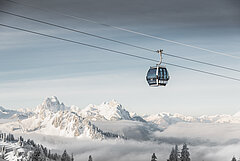 Fokus ist auf der Saanersloch Gondelbahn mit verschneitem Bergpanorama im Hintergrund